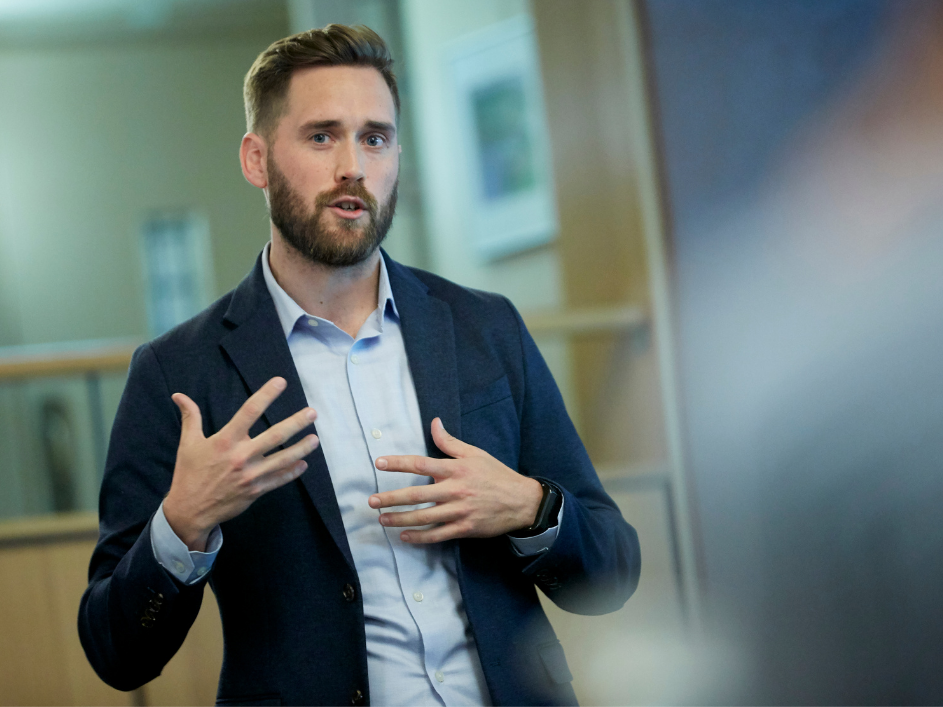 A DeGroote professor presenting while gesturing.