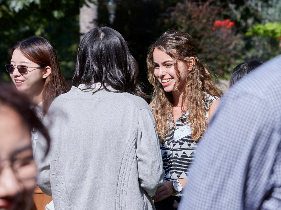 A student smiling while speaking with an advisor.