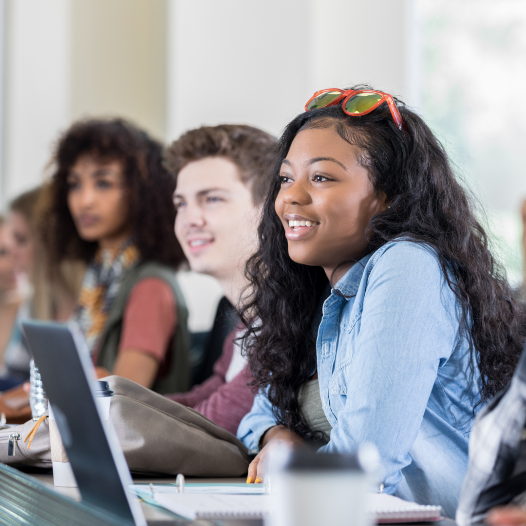 A group of students attentively listening to their professor off-screen.