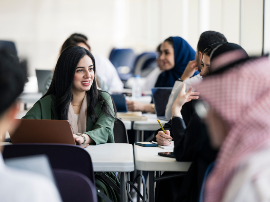A student speaking with two advisors at a table.
